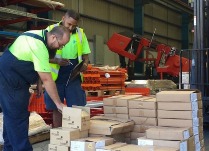 two workers conducting an inspection of delivered goods