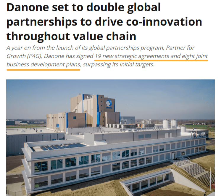 News headline and photo of Danone facility, announcing Danone's plan to double global partnerships and noting the signing of 19 strategic agreements and 8 development plans